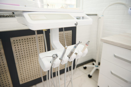 Modern equipment in while light dental office interior. Dentistry. Medical clinic, outpatient hospital. Copy advertising space. Selective focus on dental tools for treating teeth. Dental practice.の写真素材