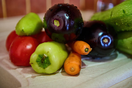 Still life with washed fresh ripe organic vegetables on a kitchen countertop sink. Eggplants, carrots, tomatoes, bell peppers - ingredients for making ratatouille or stew. Food background. Close-upの写真素材
