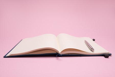 Still life with a silver pen on notebook, notepad, scratch pad with empty blank pages for dates, notes and schedules, isolated background. The concept of business, office and management organization.の写真素材
