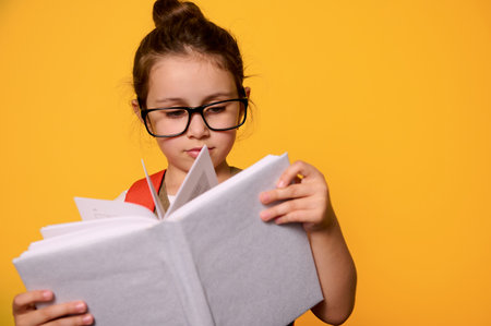 Close-up Caucasian smart primary school girl in casual dress, carries an orange school bag, looking...
