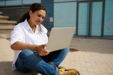 Multitasking businesswoman, entrepreneur, developer, sales manager expressing difficulties, thinking on business development strategy, using laptop, online working. People. Career. Brainstormingの写真素材