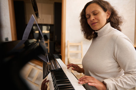 Young adult multi ethnic woman learning basic of classic piano at home. Practicing chord instrument. People, leisure activity, hobbies and lifestyleの写真素材