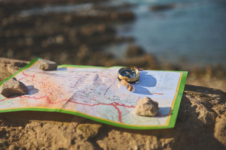 Still life with geographic map and old golden compass with a magnetic arrow showing the north direction during travel. Trip. Tourism. Travel concept. Discovering new travel destinationsの写真素材
