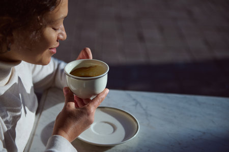 Details of a white elegant ceramic porcelain cup with the remains of a coffee drink in a happy...
