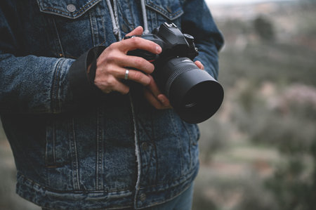 Close-up professional camera in the hands of male traveler photographer. People. Travel. Tourism and...