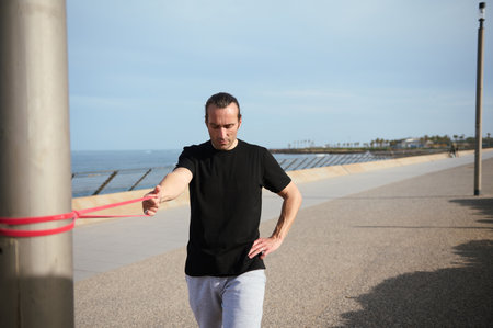 Caucasian handsome confident determined young athletic man in black t-shirt nd sports shorts,...