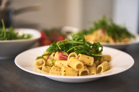 Food background with a plate of Italian pasta penne a la Amatriciana with pancetta bacon, tomatoes and pecorino cheese. Italian cuisine and culture. Still lifeの写真素材