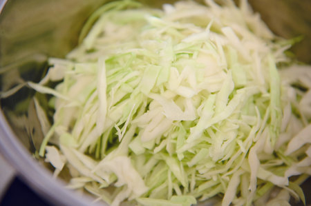 Close-up view. Chopped raw juicy cabbage in stainless steel saucepan. Directly aboveの写真素材