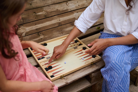 A mother and daughter engaged in a game of backgammon, capturing a moment of bonding and quality...