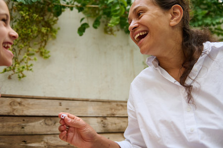 A joyful moment captured between a mother and daughter, sharing laughter outdoors. The connection...