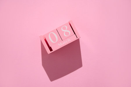 Pink wooden calendar displaying March 8 on a pastel pink background, representing International Women's Day and feminine celebration.の写真素材