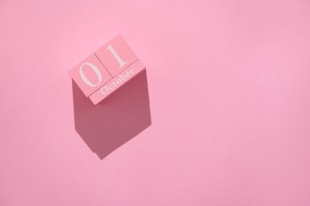 Calendar block showcasing October 1 against a pink backdrop, emphasizing the fresh start of the month with a playful theme.の写真素材