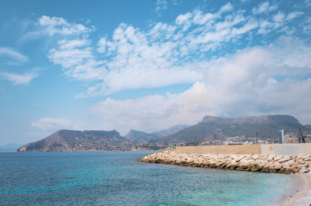 Beautiful coastal landscape featuring mountains, clear blue skies, and tranquil waters. Ideal representation of natural beauty and serene sea vibes.の写真素材