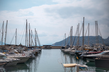 A peaceful marina scene featuring numerous yachts and sailboats, with calm waters and a mountainous backdrop, conveying a sense of leisure and escape.の写真素材