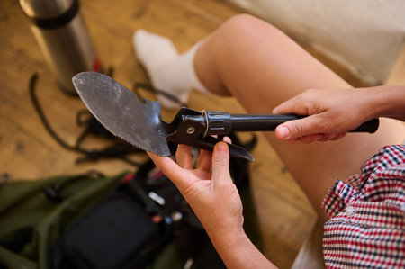 Close-up of a person preparing a multi-use camping tool, emphasizing outdoor adventure and readiness.の写真素材