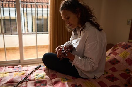 A woman sits on a bed playing a ukulele in a warmly lit room, creating a serene and intimate...
