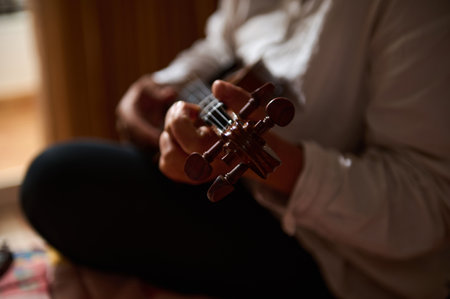A serene close-up of someone skillfully playing an acoustic guitar, highlighting the details of the instrument and the hands. The image captures a warm, intimate musical moment.の写真素材