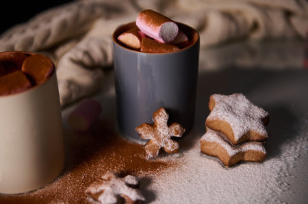 A warm setting featuring steaming hot cocoa topped with marshmallows and powdered cookies.