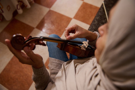A close perspective of a person skillfully playing a violin, focusing on hand positioning and...