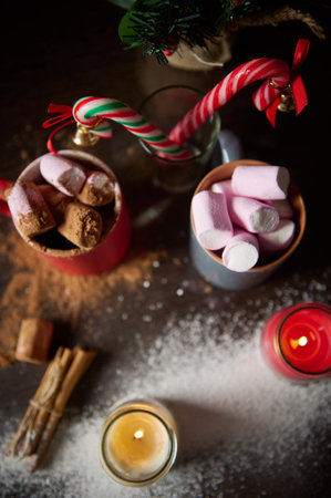 Top view of a cozy holiday scene with marshmallows, candy canes, and candles. Perfect for creating warm festive cheer and celebrating Christmas with delight and comfort.の写真素材