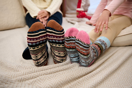 Close-up of colorful socks worn by two people sitting on a bed, emphasizing warmth and coziness.