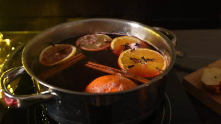 A steaming pot of mulled wine infused with citrus slices, cinnamon, and cloves creates a warm and inviting atmosphere, ideal for cozy gatherings or holiday festivities during the chilly season.の写真素材