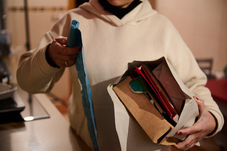 A person arranges various materials in an envelope, demonstrating care and attention to detail. The...