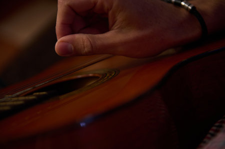 A detailed view of someone strumming an acoustic guitar with natural lighting and cozy ambiance.