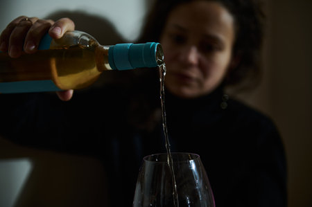 Liquid pouring into a glass with a focus on the flow, capturing elegance and depth.の写真素材