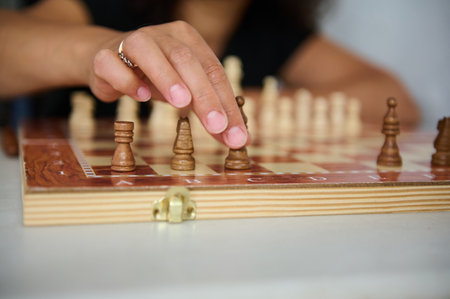 A close-up photograph of a chess player moving a chess piece on the board.の写真素材