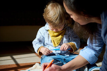 A young child engaged in an activity, accompanied by their mother, creating a warm and intimate...