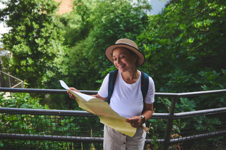 Woman smiling while reading a map outdoors, surrounded by lush greenery under the sun. Represents...