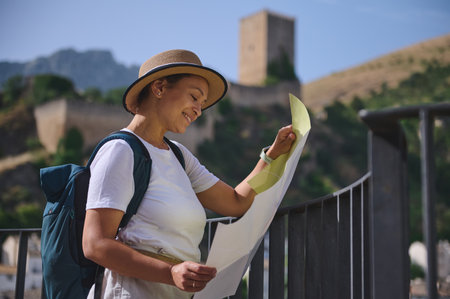 A female traveler enjoys discovering a historic city, holding a map amidst stunning medieval...