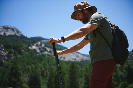A seasoned traveler enjoys hiking in a lush mountainous terrain under a clear blue sky, capturing the essence of adventure and nature's beauty.の写真素材