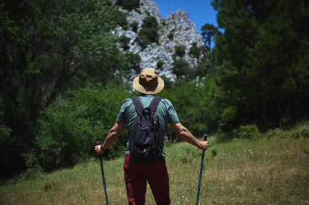 Traveler navigating lush greenery and rugged mountains while enjoying an adventurous and active lifestyle. Perfect for concepts of hiking, exploration, and reconnecting with nature.の写真素材