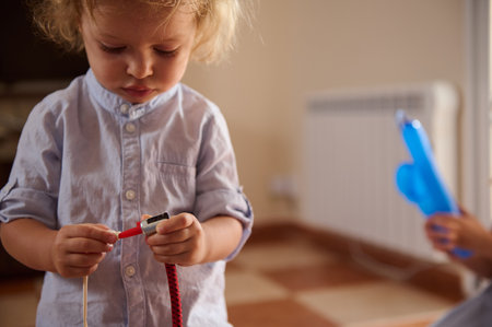 A young child investigates objects with curiosity, capturing a moment of exploration and learning in...