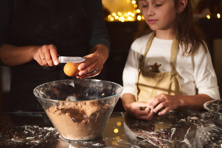 A warm, festive scene of a parent cracking an egg into a flour-dusted bowl while a young girl in an...