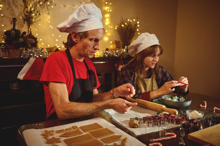 Two chefs wearing white hats bake holiday cookies in a cozy, festive kitchen, rolling dough and...