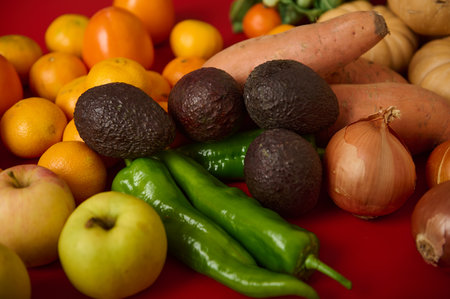 Colorful display of fresh produce featuring avocados, peppers, apples, onions and citrus, set...