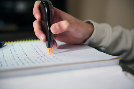Teenage student studying homework in a cozy home interior using correction tape on a notebook in the...