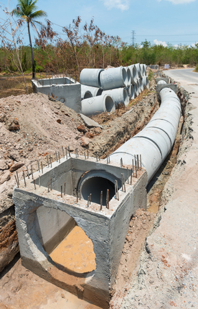 Row of Concrete Drainage Pipe on a Construction Site .Concrete pipe stacked sewage water system aligned on site.の写真素材