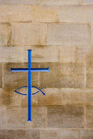 Engraving of a cross and fish in a stone wallの写真素材