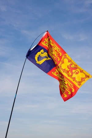 A Royal Standard Flag fluttering against a blue skyの写真素材
