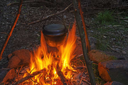 Cooking in cauldron.Dinner cooks in a large pot over an open fire.の写真素材