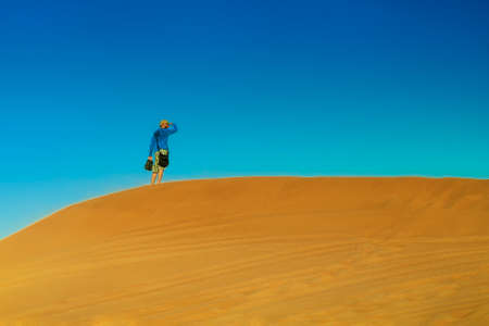 Alone in the desert.In the wilderness.Man stands alone on the sand dune.Traveling in the Sahara.の写真素材
