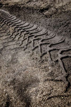 footprints of motorcycle tires on beach sandの写真素材