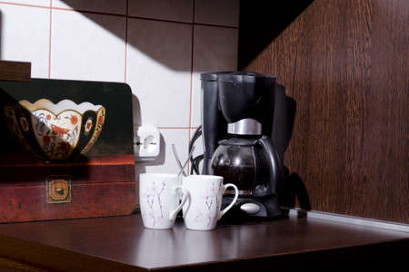 coffee makers and two cups of coffee scoop in the morning sunの写真素材