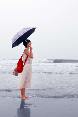 The girl standing by the seaの写真素材
