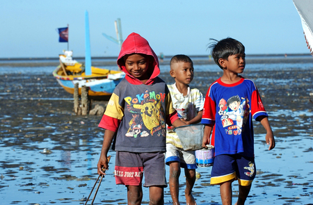 Childrens playing on the beach Kenjeran, Surabaya, East Java, Indonesia over on June 13th, 2003.のeditorial素材