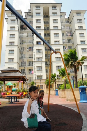 A child playing swing in an apartment in Putra Jaya, Malaysia. Photo taken, APRIL 21, 2010.のeditorial素材